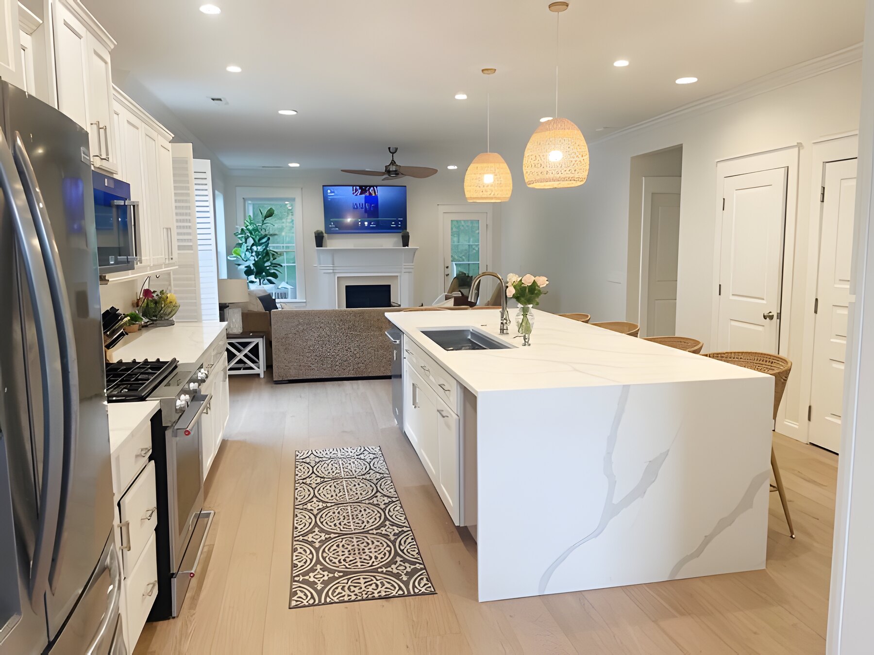 Open kitchen with waterfall quartz island flowing into the living room