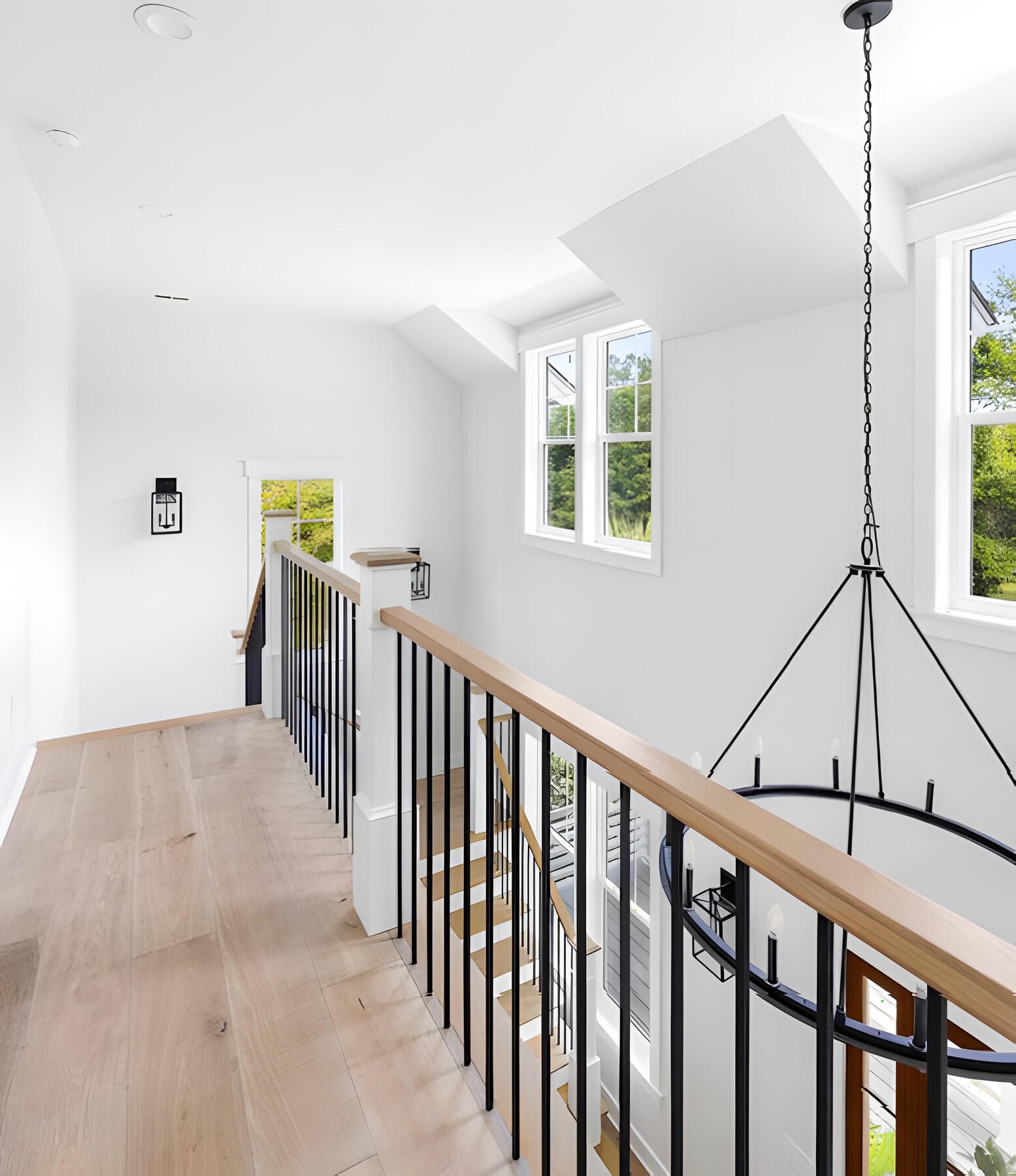 Upstairs landing with iron stair rail and lantern chandelier