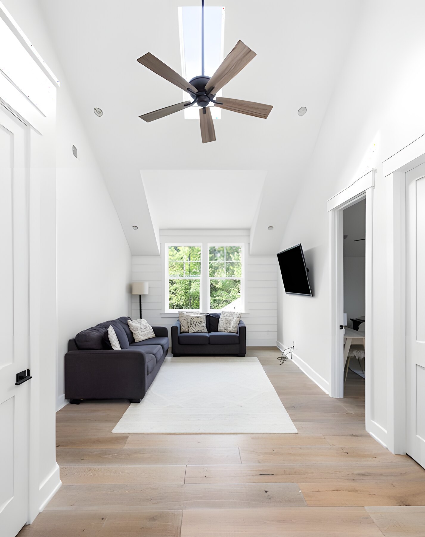 Vaulted bonus loft with shiplap accent wall and oak floors